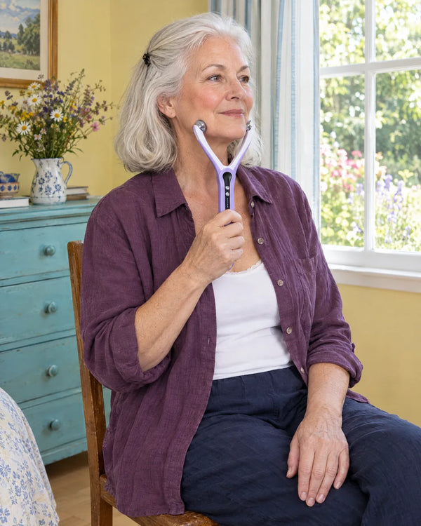 AI-created lifestyle illustration of an adult using the Purple facial roller.